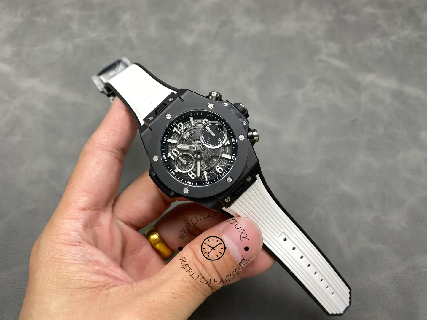 Full watch in hand: Hublot Big Bang Unico 441.CI.1171.RX with black case and white rubber strap.