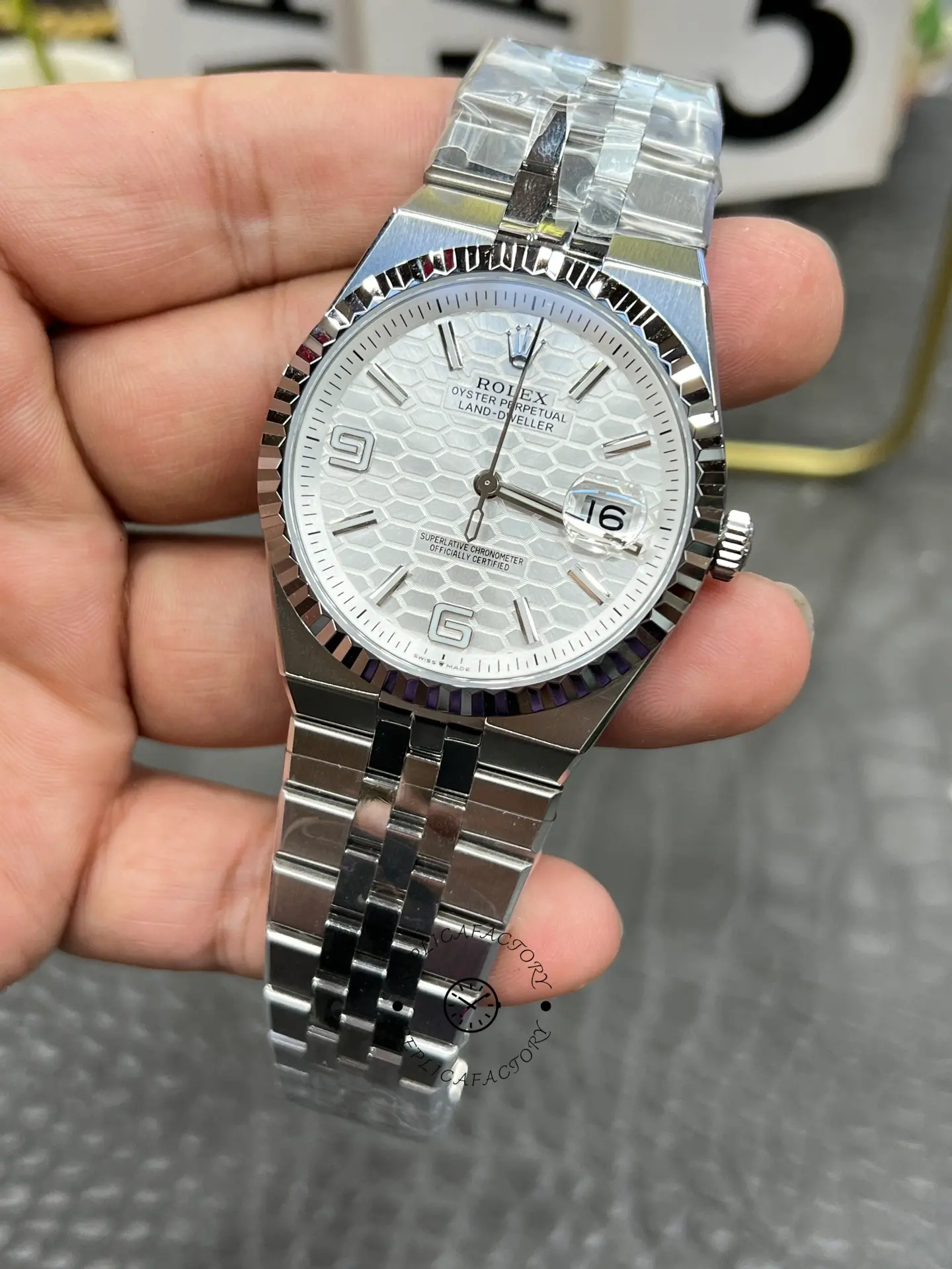 Three-quarter view of Rolex Land-Dweller 40 M127334-0001 replica showing integrated bracelet and date window.