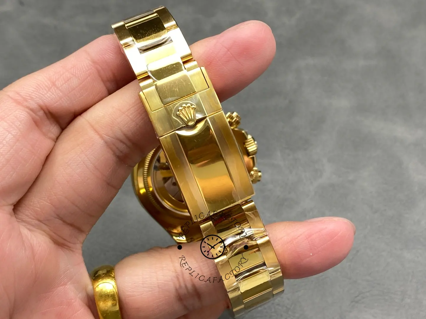 Clasp detail of Rolex 126528LN yellow gold Oyster bracelet with engraved crown logo.