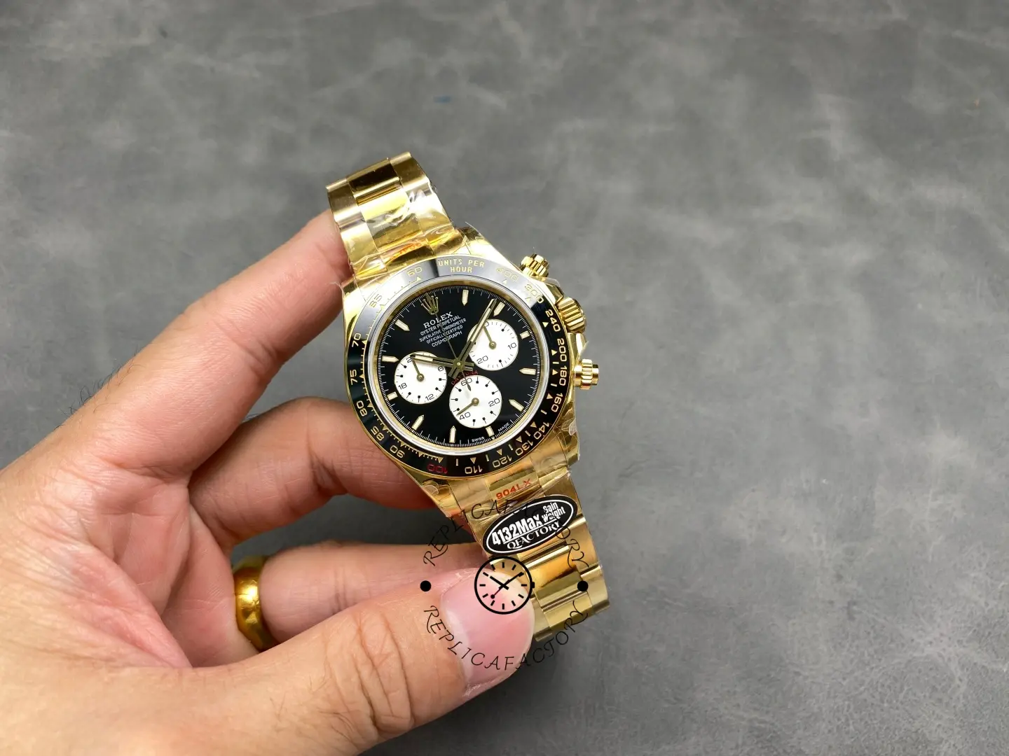 Full hand-held view of Rolex 126528LN Le Mans Daytona with yellow gold bracelet and black ceramic bezel.
