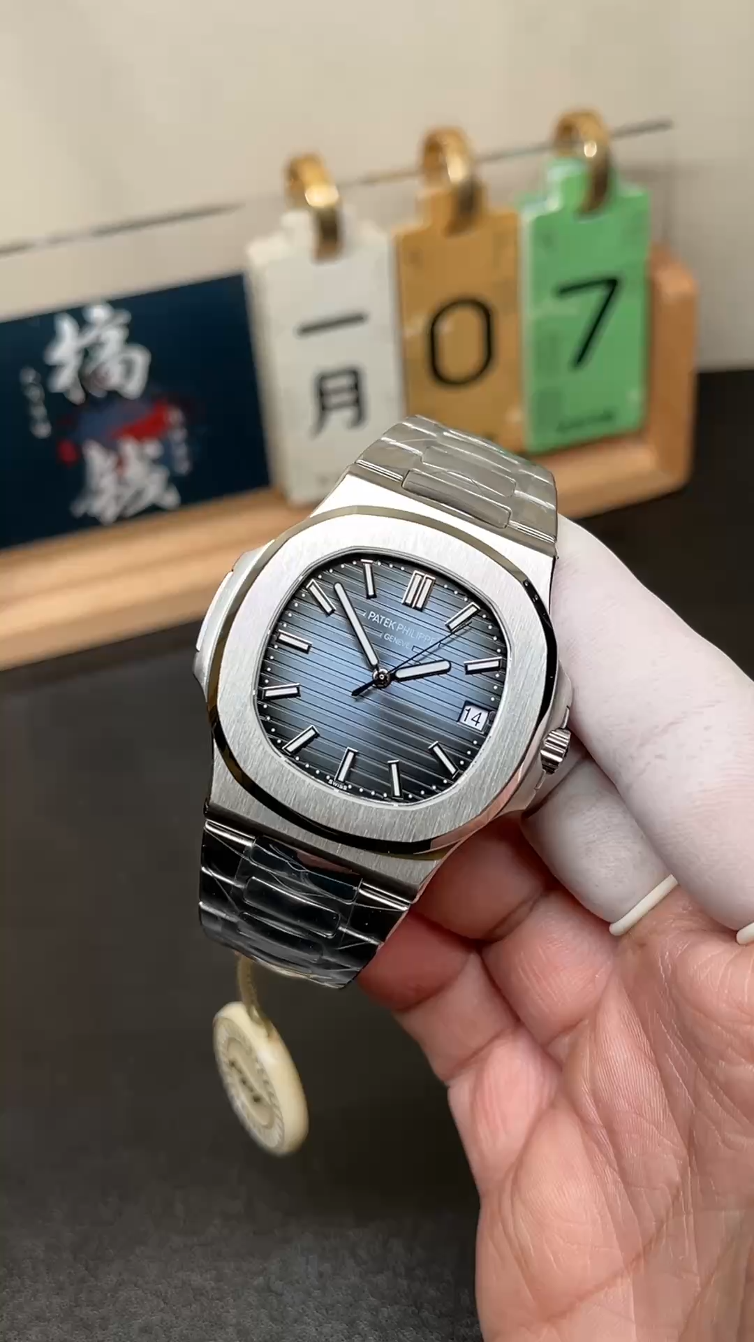 Video: hand-held Patek Philippe Nautilus 5711/1A showing blue dial shine and bracelet links. - Video