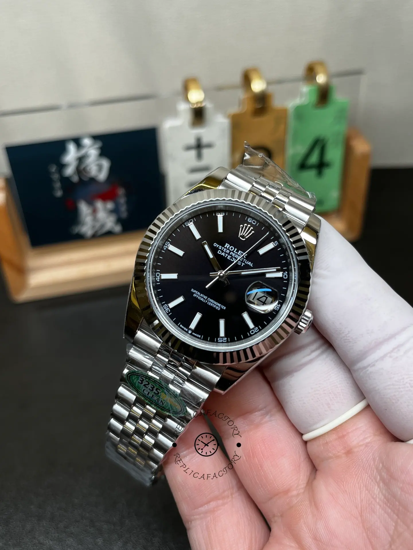 Angled hand-held front view of Rolex 126334-0018 with black index dial, cyclops date and fluted bezel.