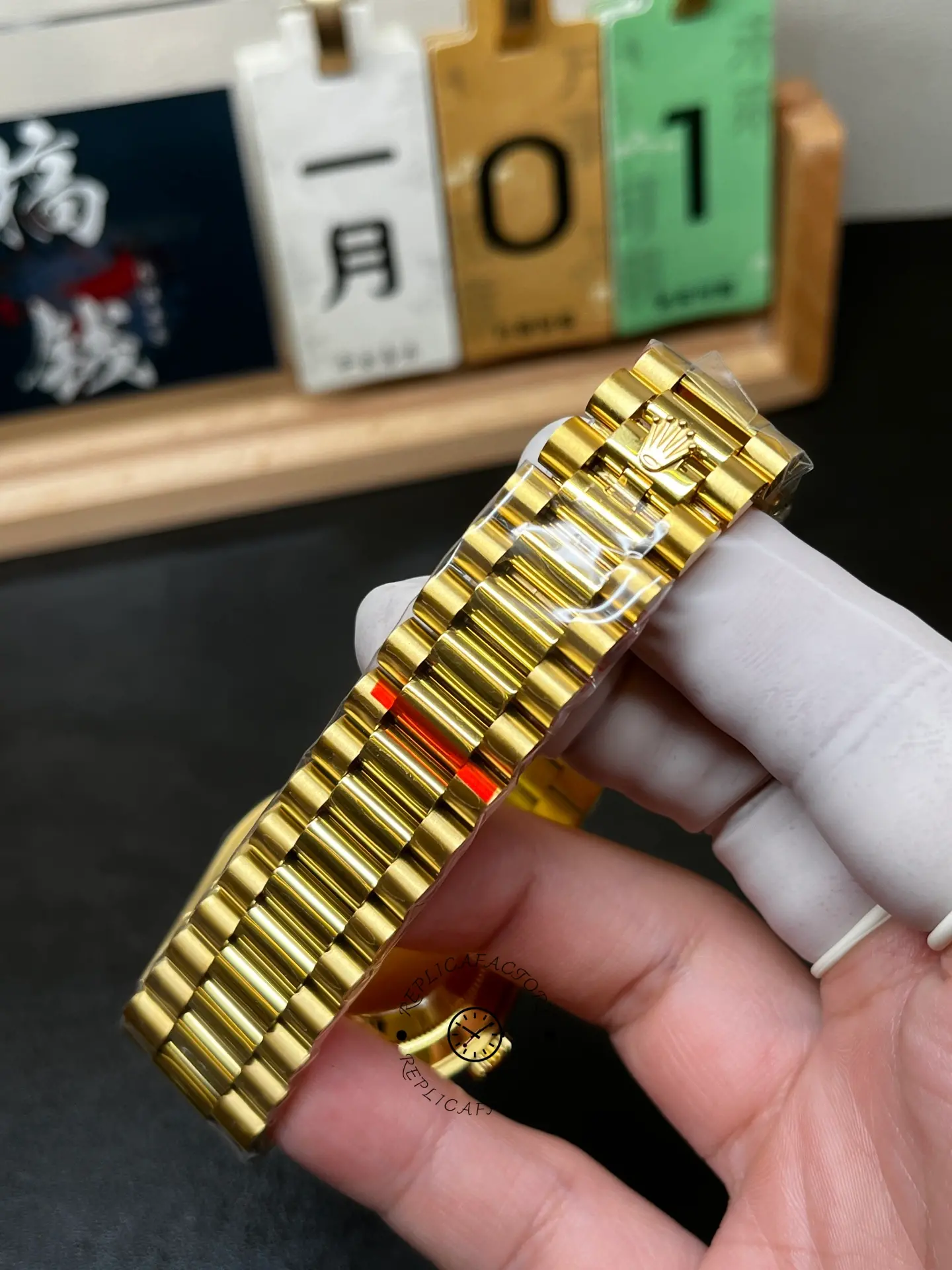 Bracelet clasp detail of Rolex Day-Date 40 m228238-0005 showing gold President bracelet and crown clasp.