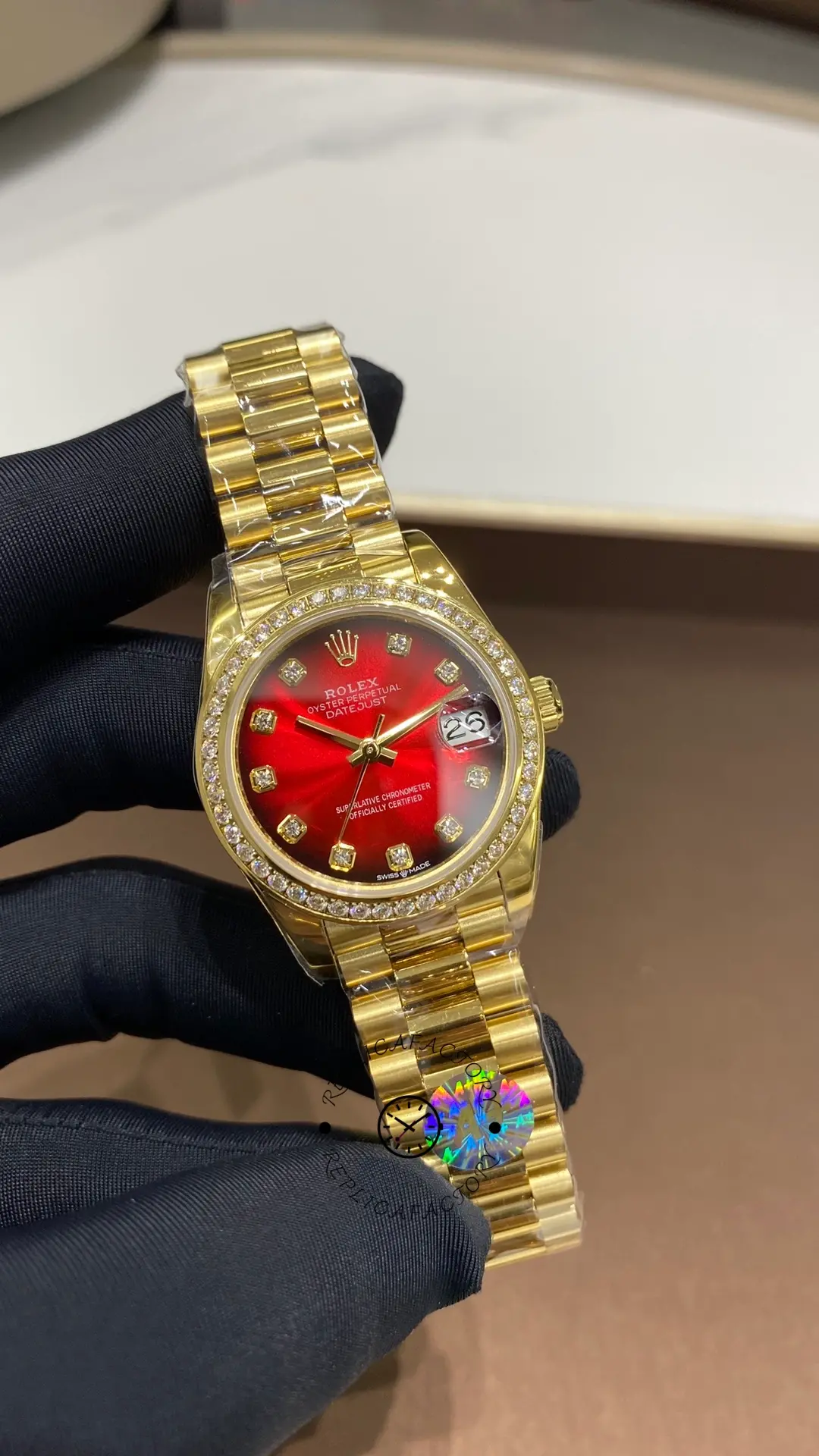Front view of Rolex Datejust 31 278288RBR-0041 showing the red dial and cyclops date magnifier on gold bracelet.