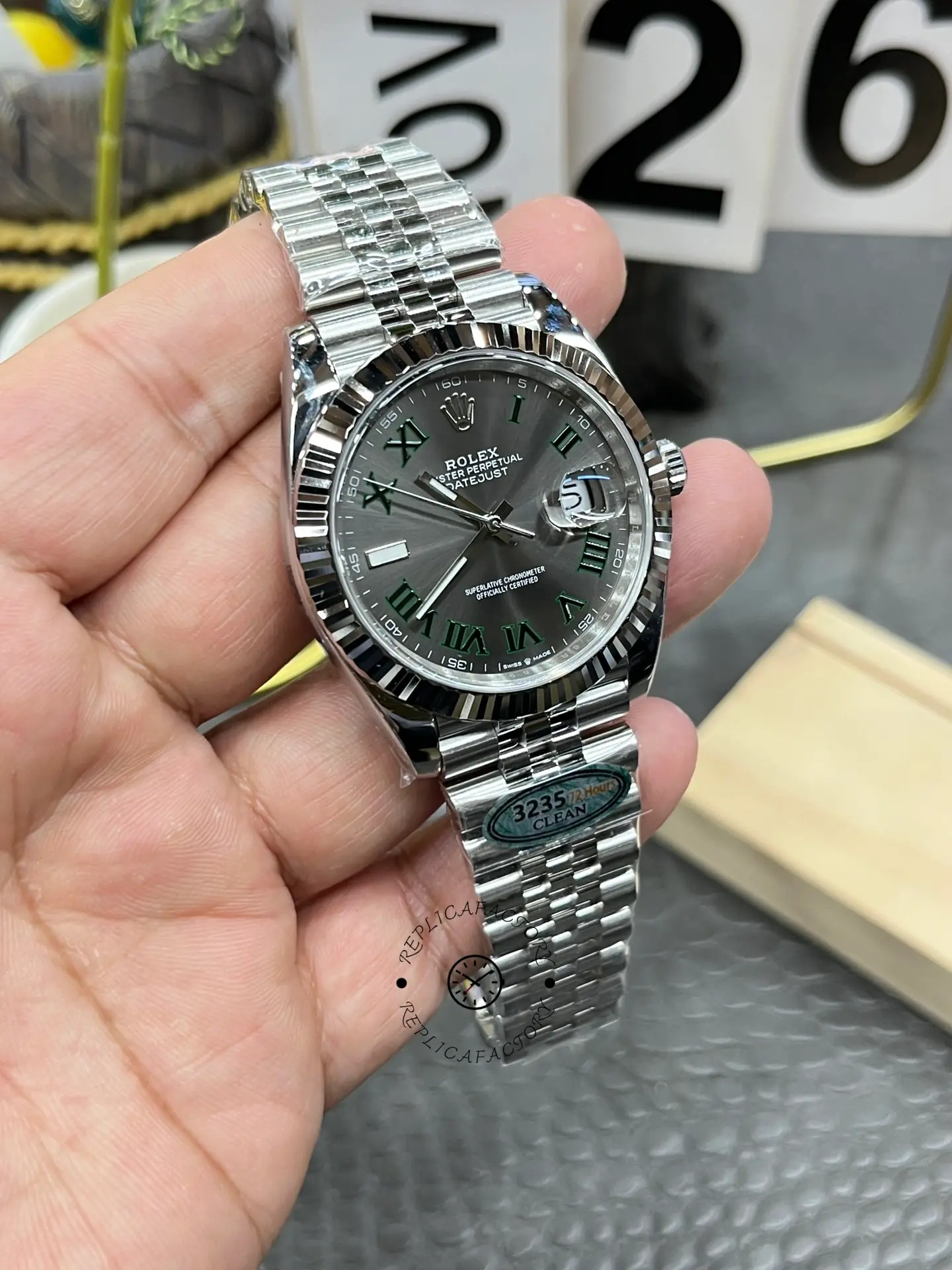 Handheld angled view of Rolex Datejust 126334-0022 with slate grey dial and fluted bezel.