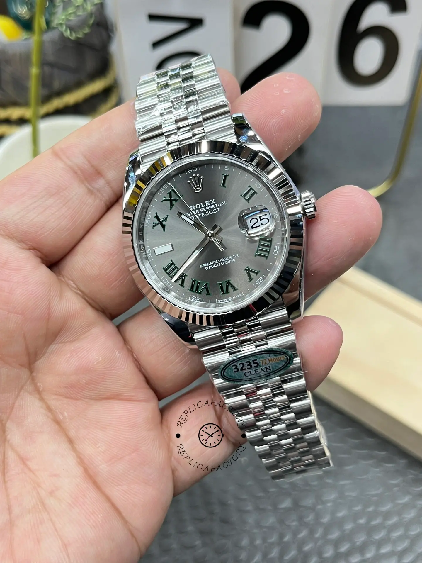 Handheld view of Rolex Datejust 126334-0022 with slate grey dial and fluted bezel.