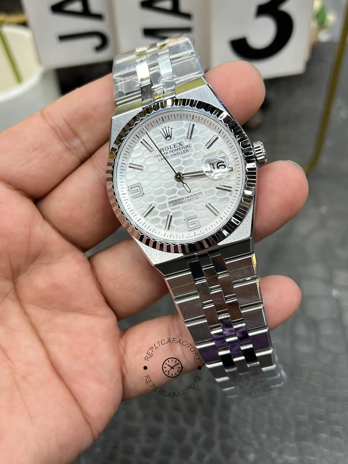 Front three-quarter view of Rolex Land-Dweller 40 M127334-0001 replica with white honeycomb dial and magnified date.
