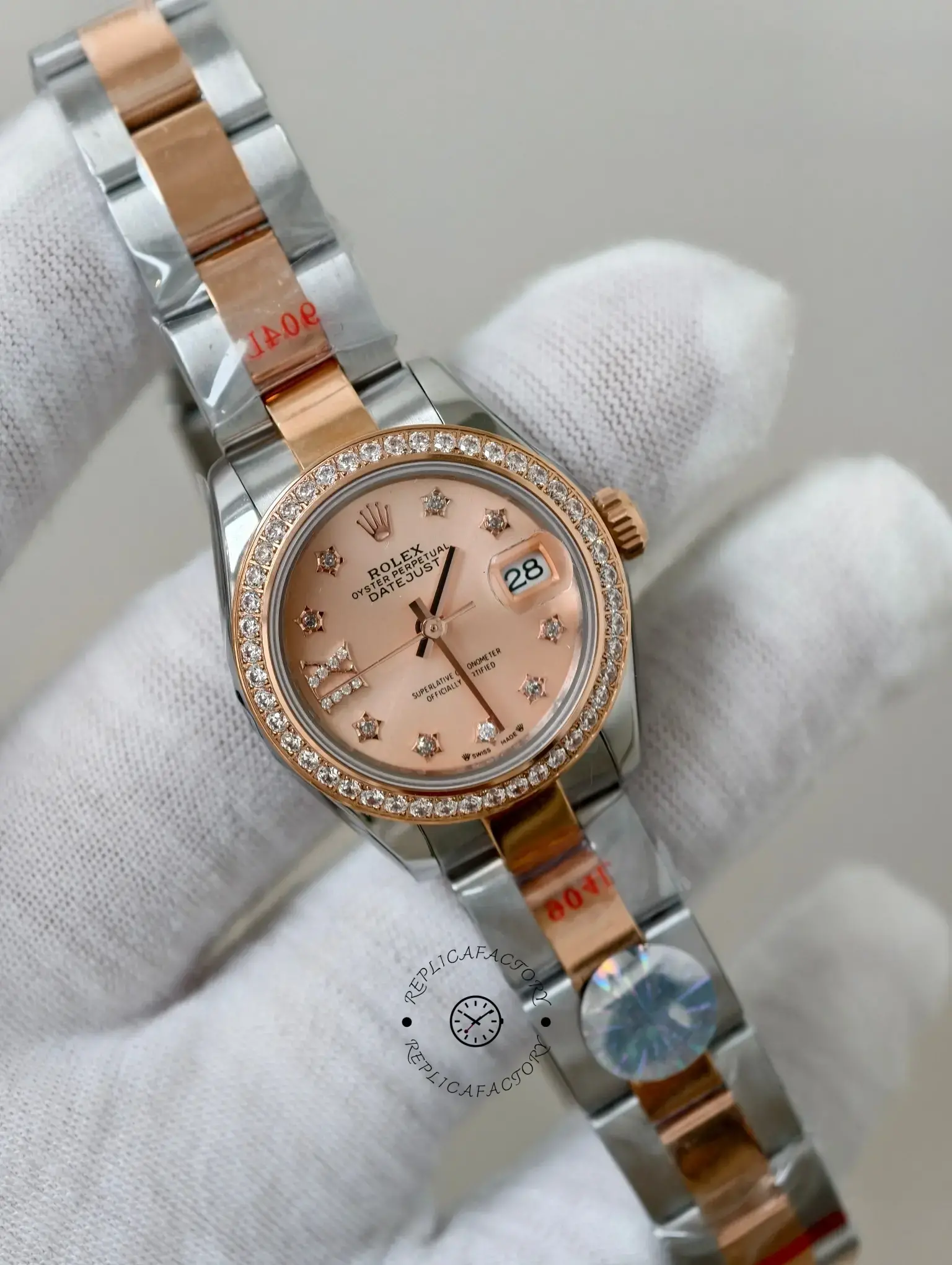 Angled front view of Rolex Lady-Datejust 279381RBR-0028 held in glove showing rose pink dial and date window.