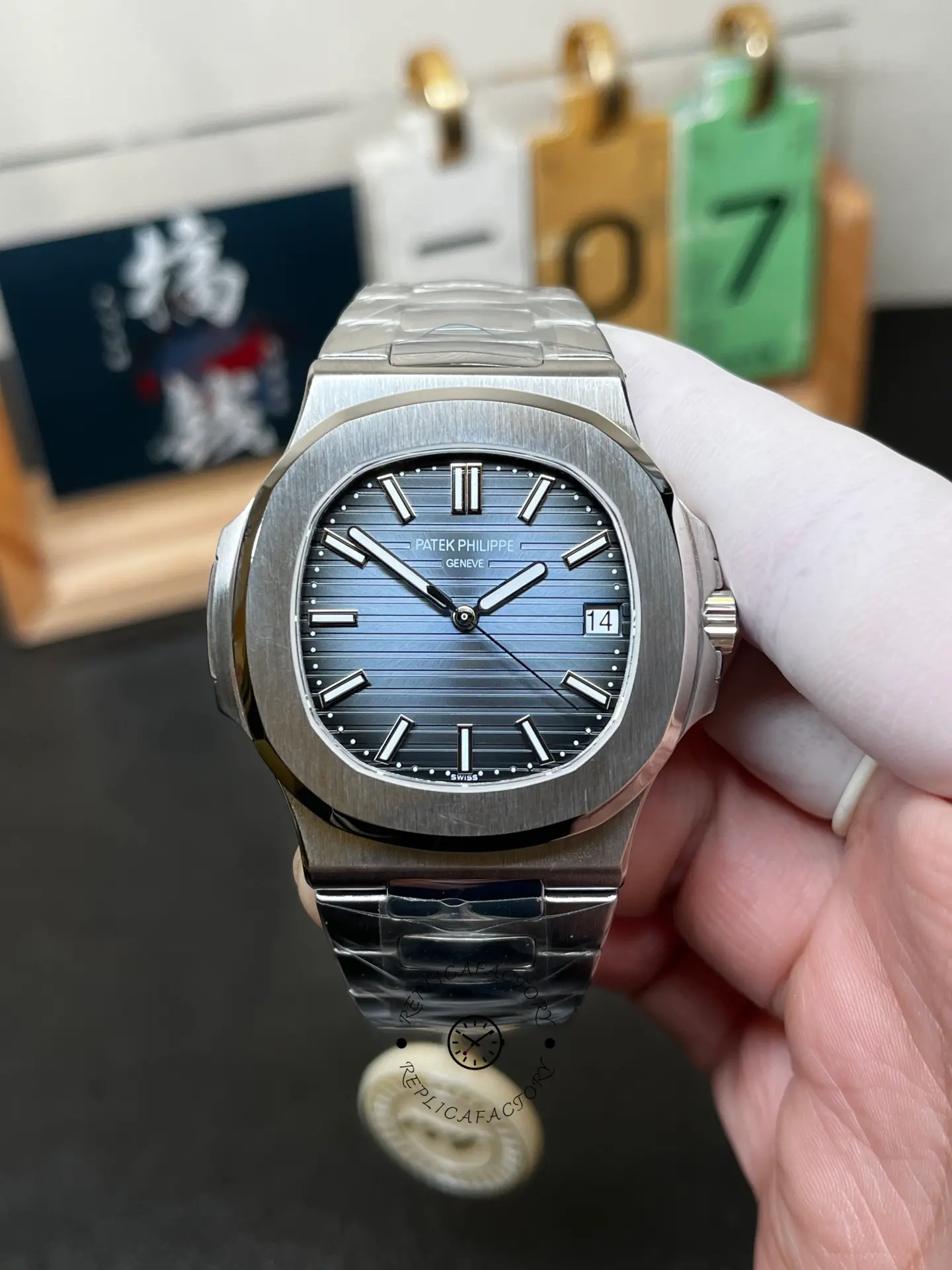 Hand-held front view of Patek Philippe Nautilus 5711/1A showing bezel shape and date window.