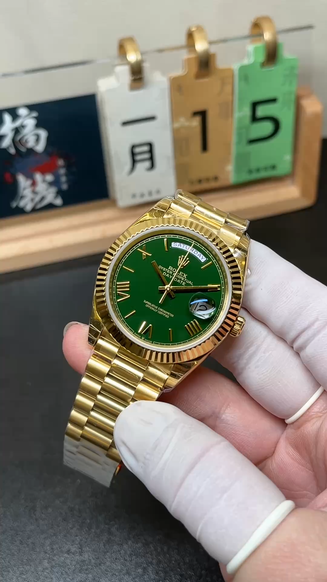 Handheld front view of Rolex 228238-0061 with green dial and yellow gold style President bracelet. - Video