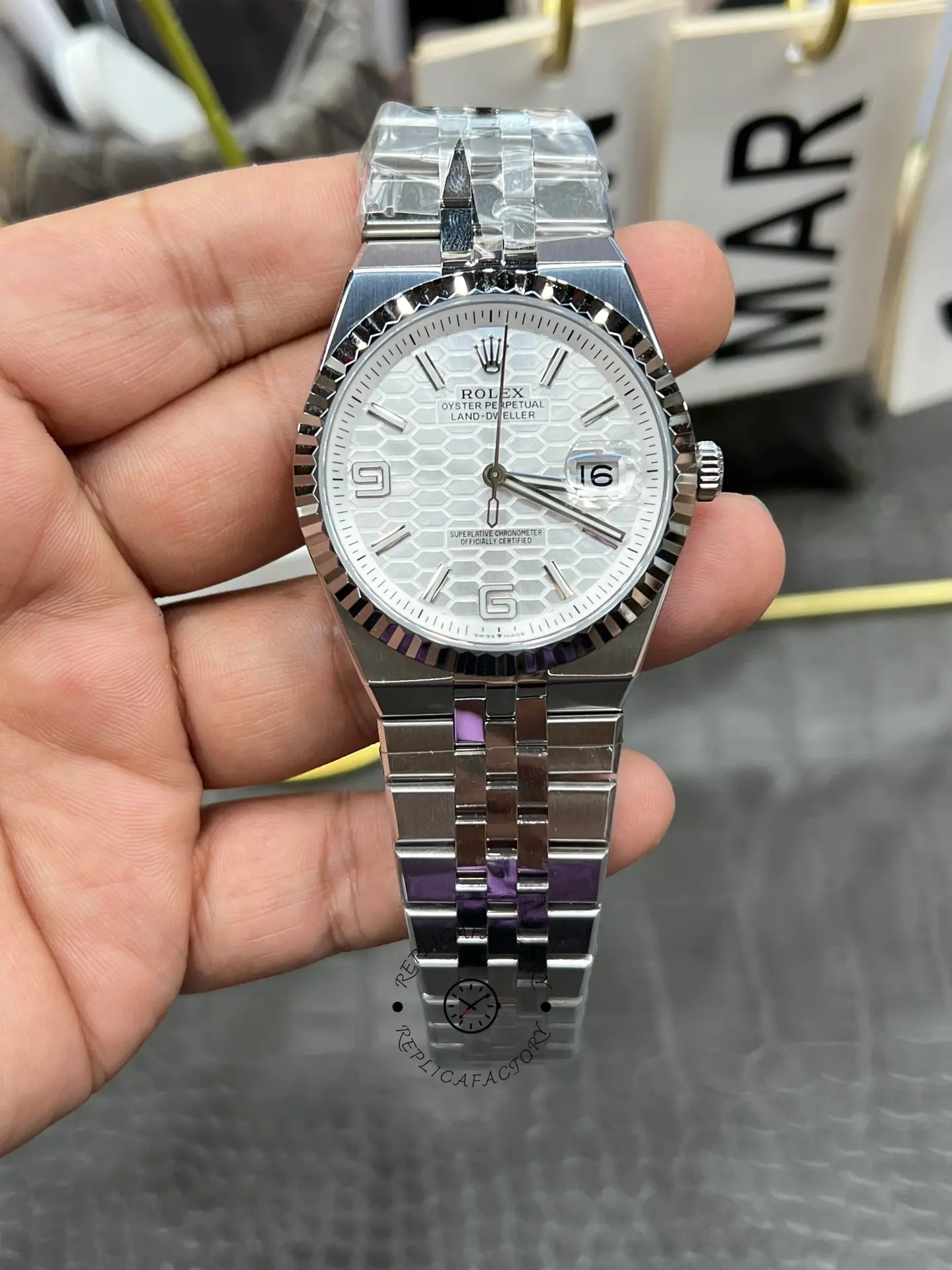 Front view of Rolex Land-Dweller 40 M127334-0001 replica with white honeycomb dial and date magnifier.