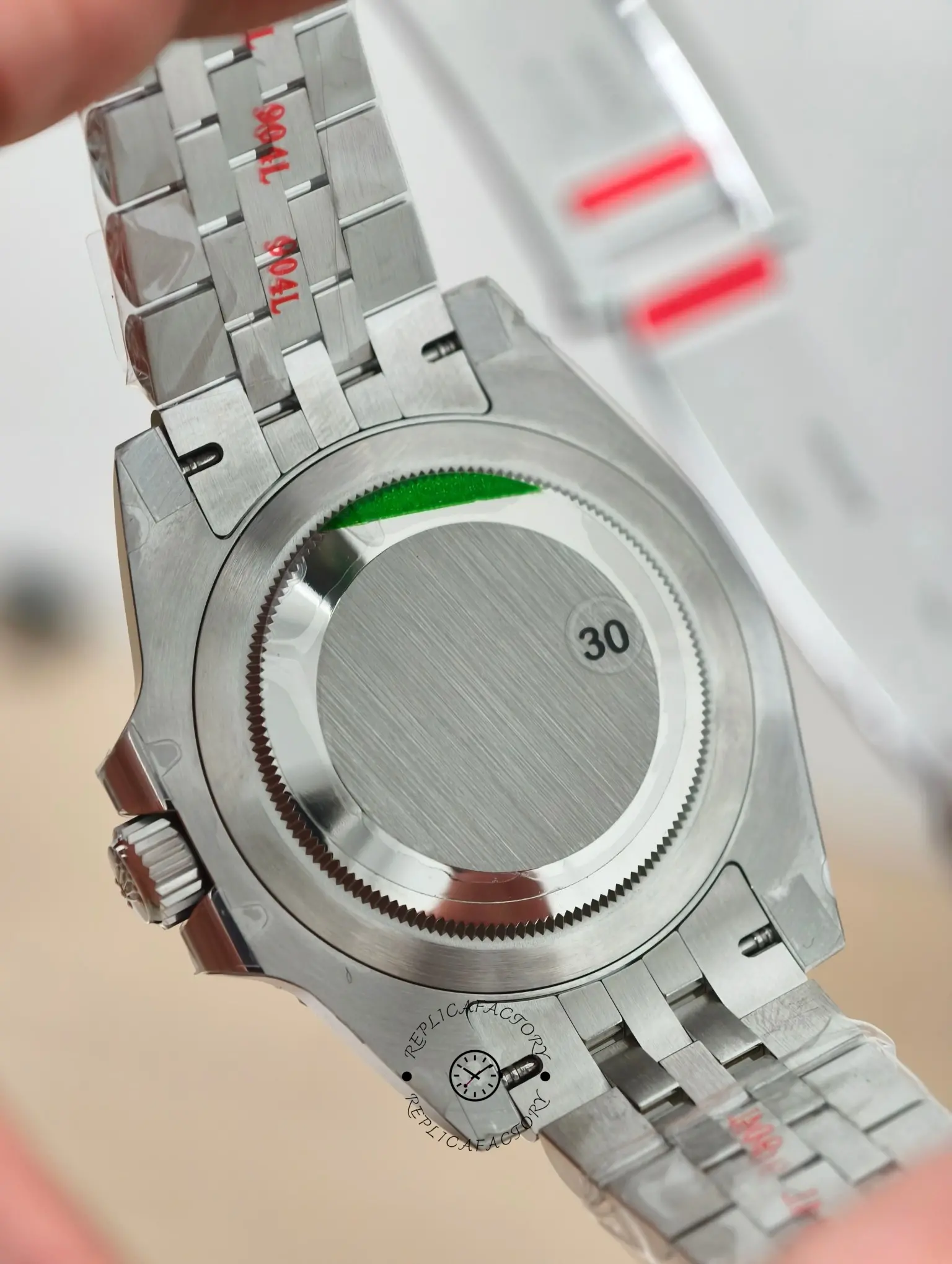 Case back view of Rolex GMT-Master II 126720VTNR with screw-down back and protective stickers on bracelet links.