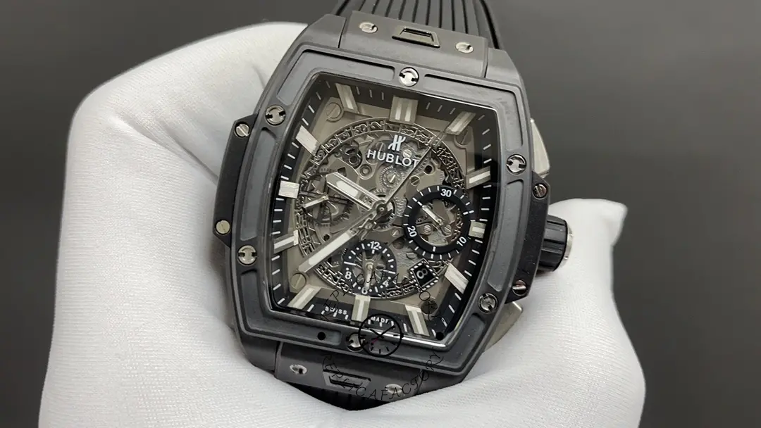 Gloved hand close-up of Hublot 642.CI.0170.RX emphasizing skeleton dial depth and marker detail.