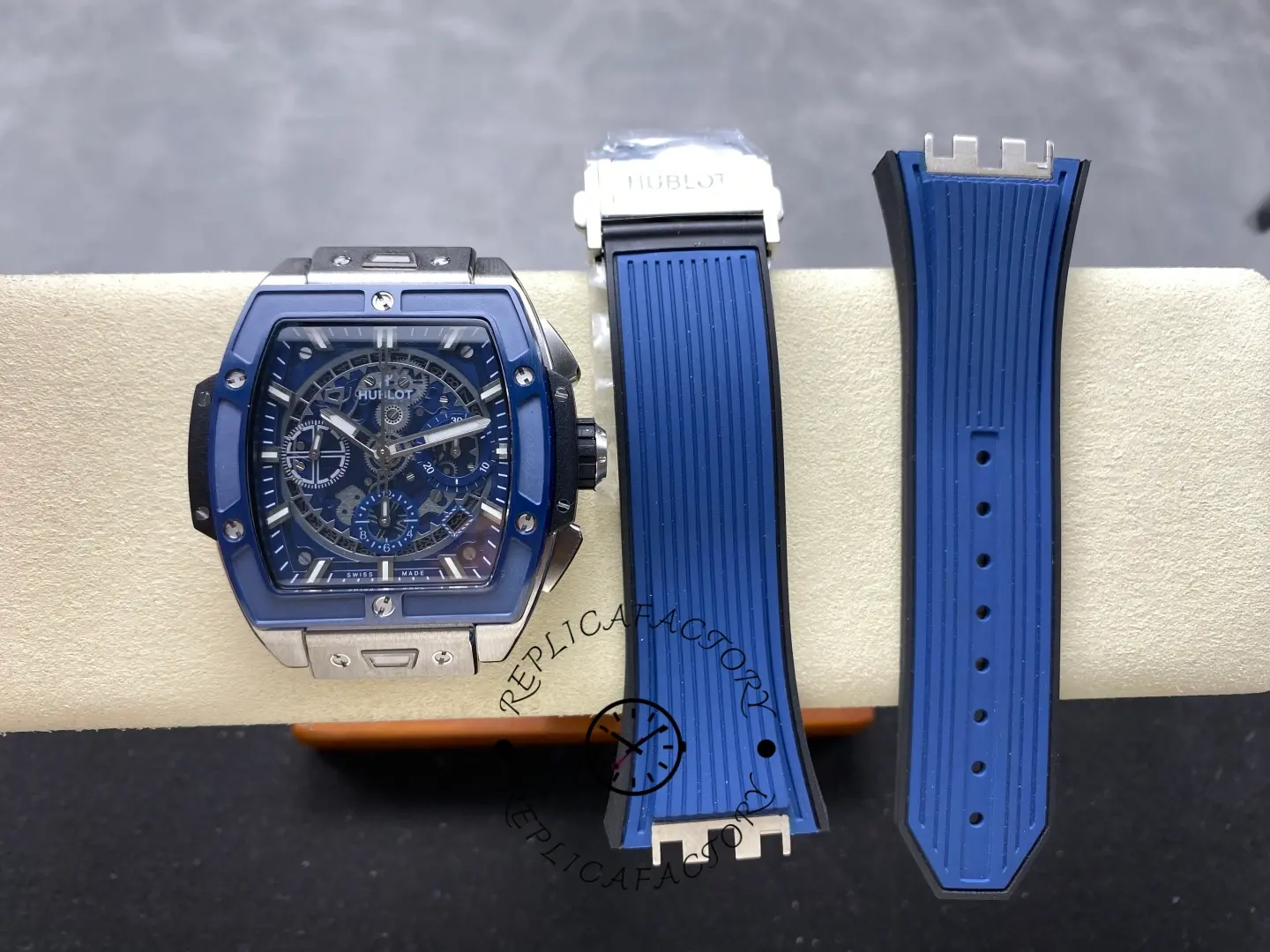 Hublot 642.NL.7170.RX on display pad with two blue strap pieces placed beside the watch.