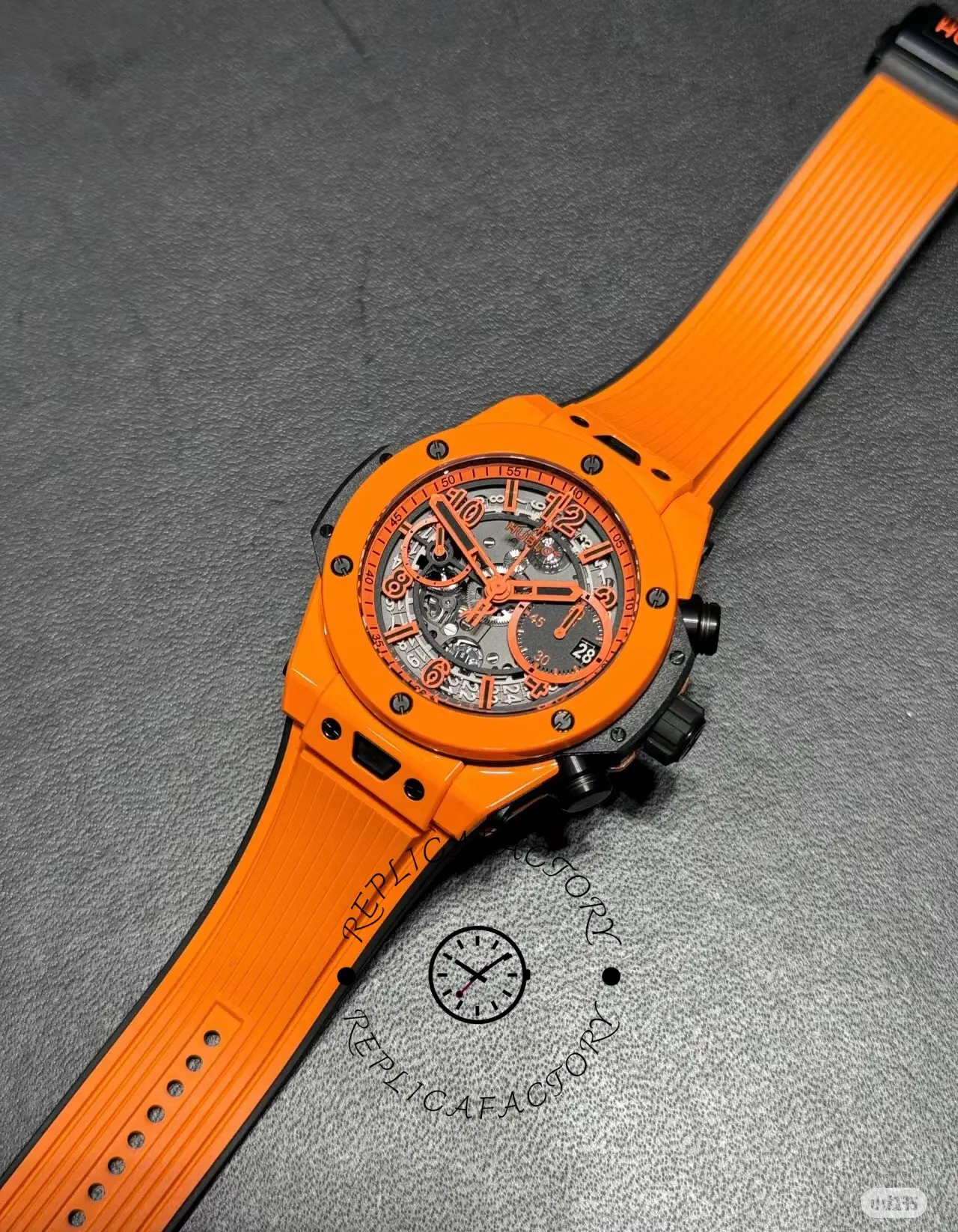 Full watch laid flat of Hublot Big Bang Unico 441.CU.5910.RX with orange strap extended straight.