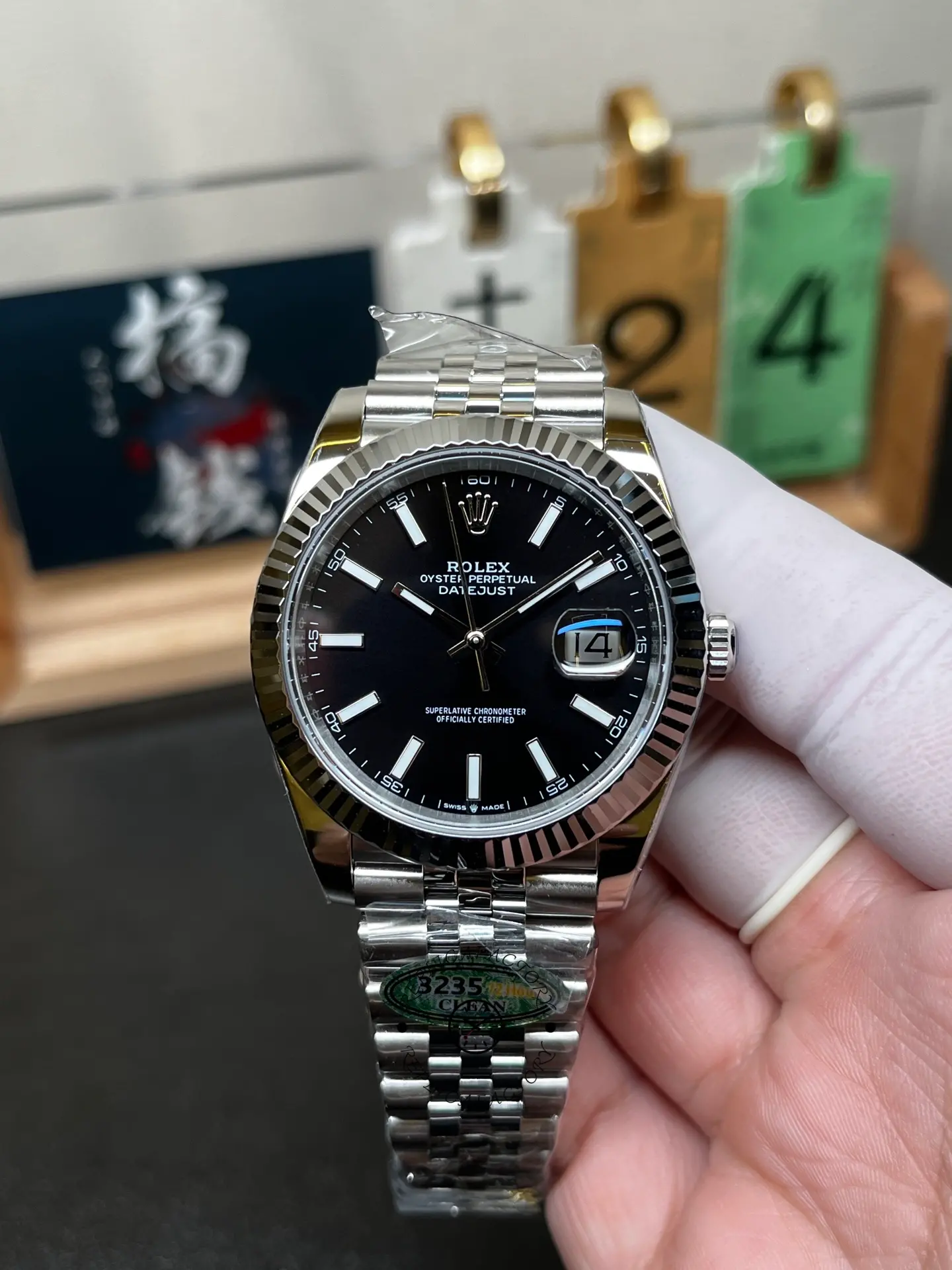 Front hand-held view of Rolex 126334-0018 Datejust 41 with black dial, fluted bezel and Jubilee bracelet.
