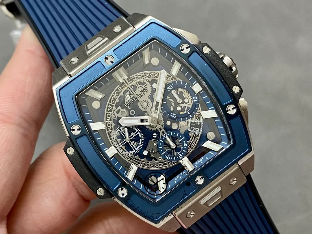 Handheld angled view of Hublot 642.NL.7170.RX emphasizing the tonneau case shape and blue bezel.