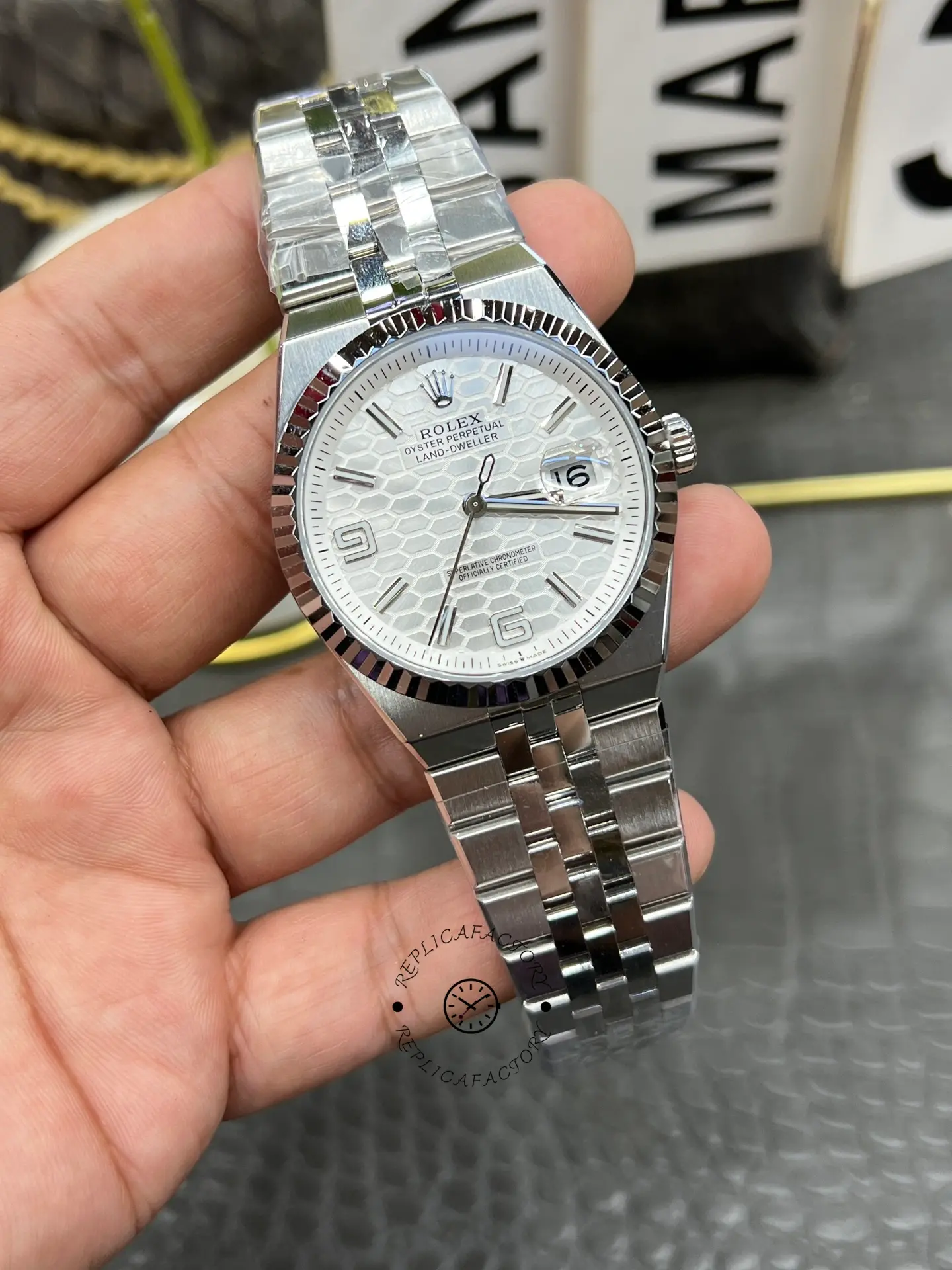 Angled front view of Rolex Land-Dweller 40 M127334-0001 replica with fluted bezel and white textured dial.