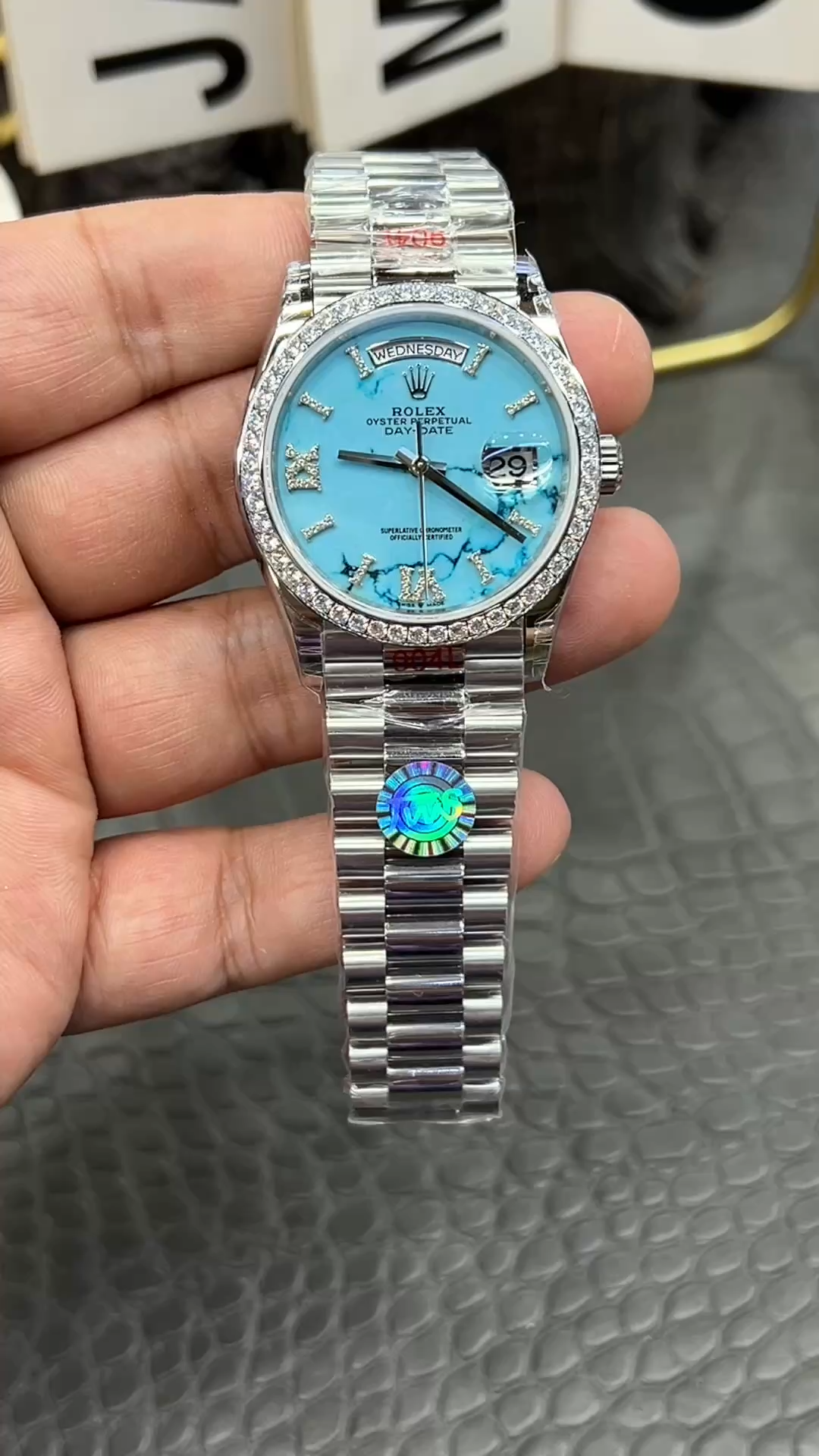 Full front view of Rolex Day-Date 36 m128396tbr-0016 in hand, showing the bracelet and dial. - Video