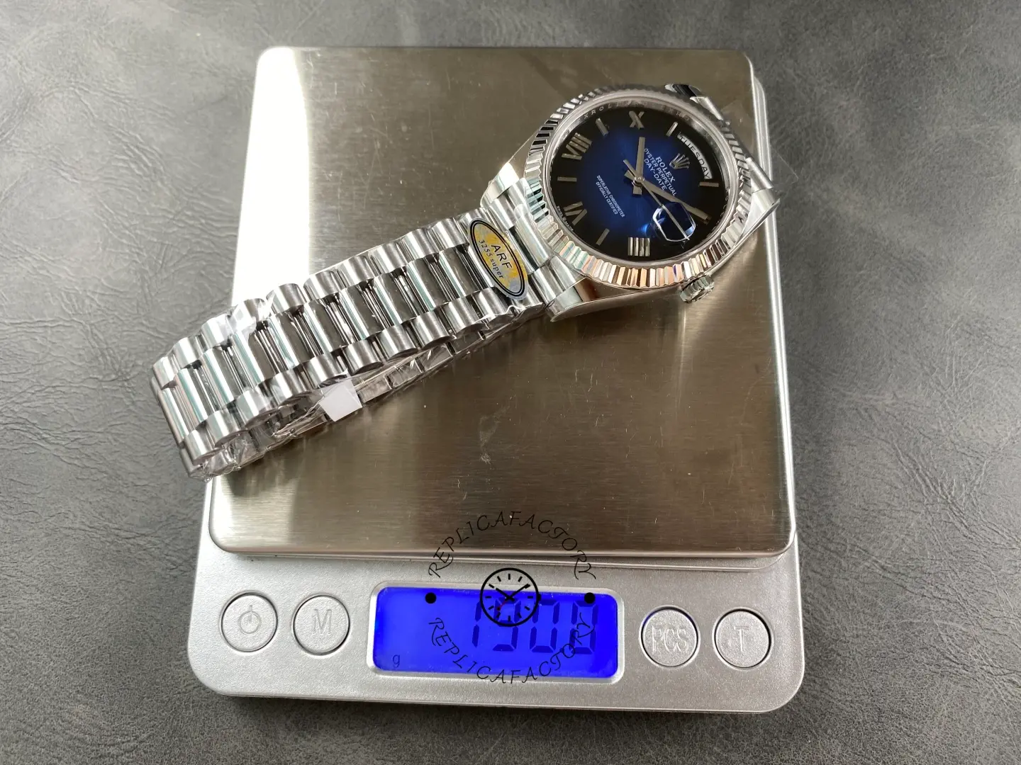 Rolex Day-Date 228239-0076 on scale showing watch weight with blue ombre dial and bracelet