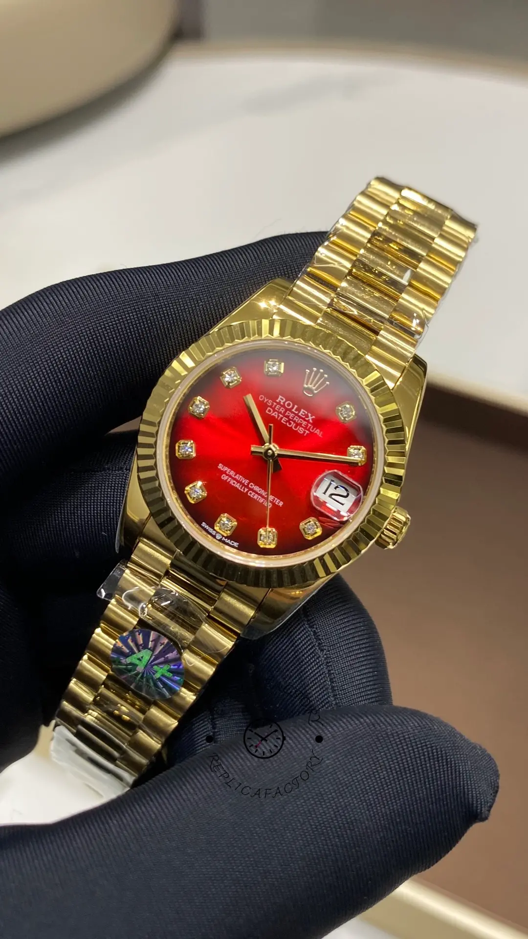 Angled front view of Rolex Datejust 278278-0049 with red ombré dial, fluted bezel and gold case.
