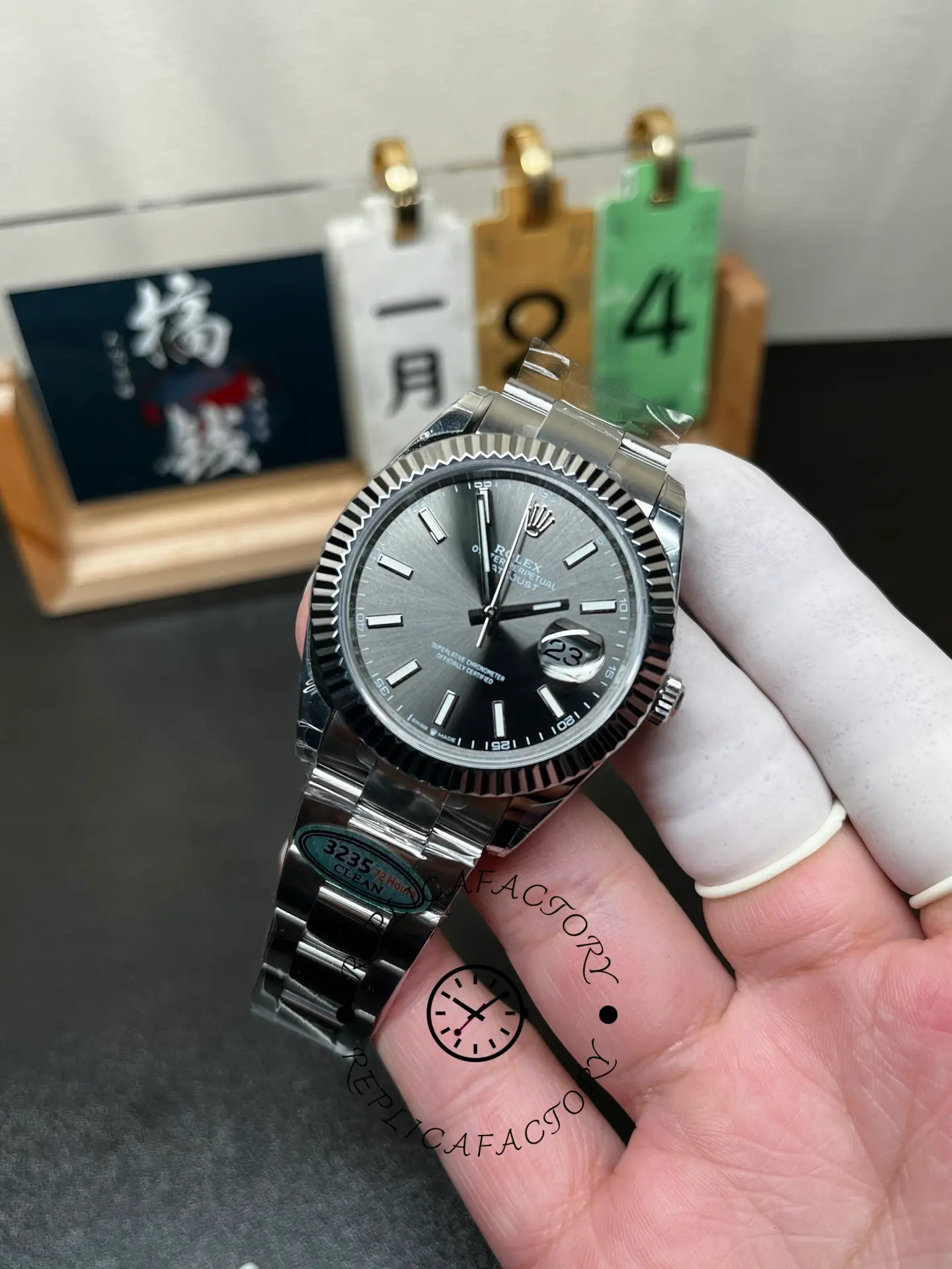 Handheld front angle of Rolex Datejust M126334-0013 with slate dial and fluted bezel.