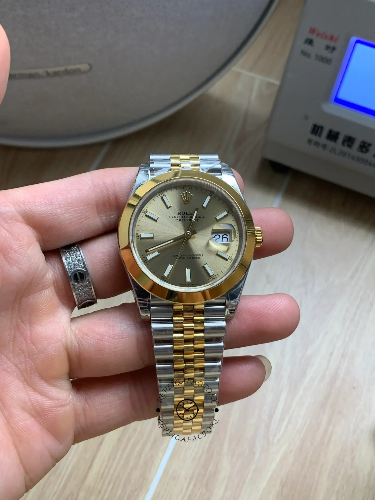 Handheld front view of Rolex Datejust 41 126303-0010 with champagne dial and two-tone Jubilee bracelet.