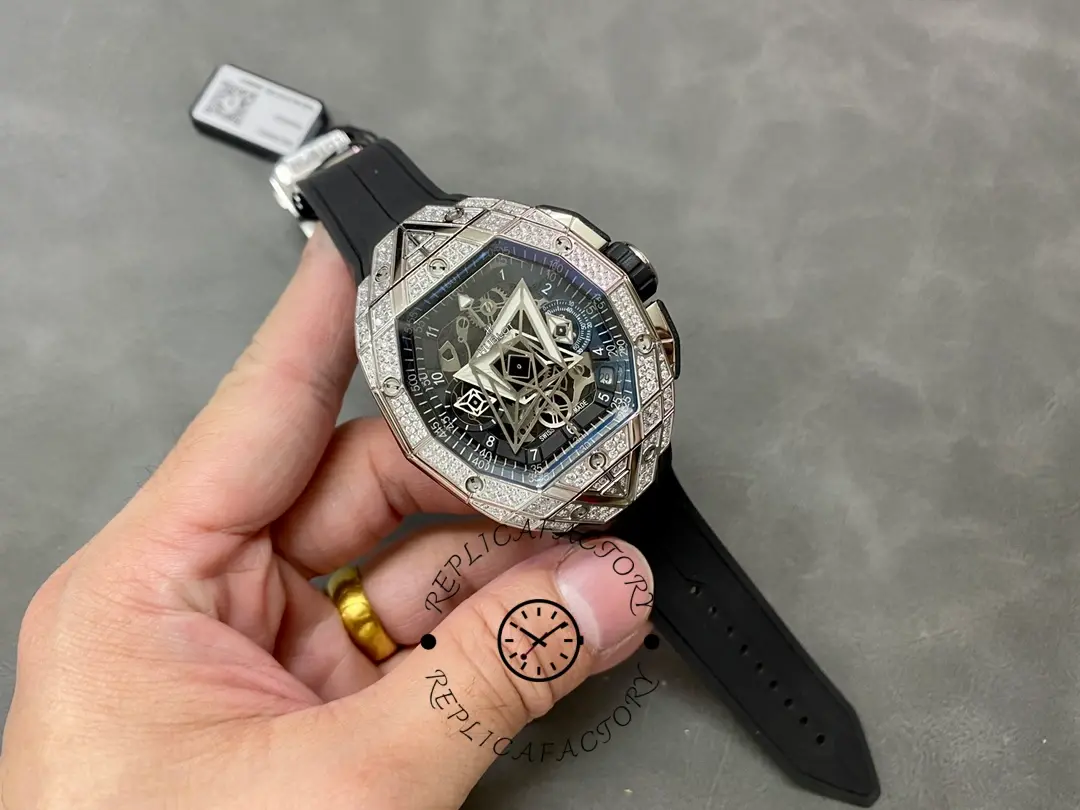 Full watch in hand of Hublot 648.NX.0107.RX.1604.MXM23 showing overall case shape and black rubber strap.