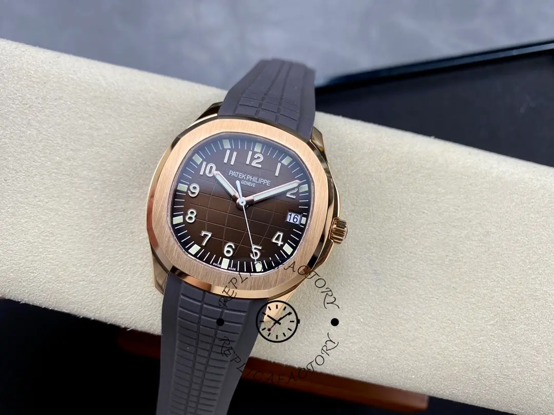 Watch on cushion: Patek Philippe Aquanaut 5167R-001 showing full case and black strap.