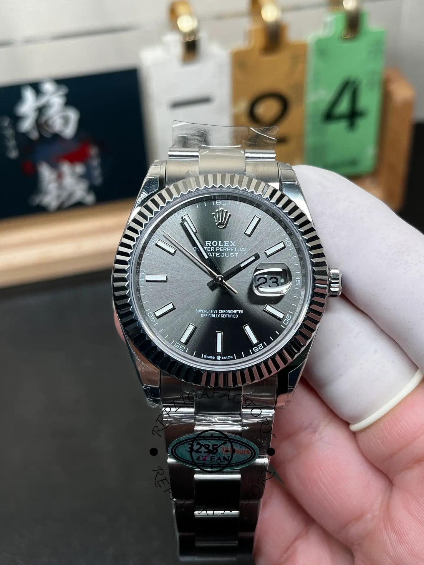 Handheld front view of Rolex Datejust M126334-0013 with slate dial and fluted bezel.