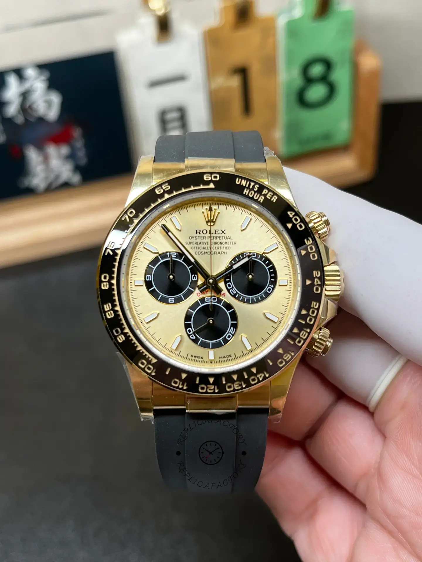 Handheld front view of Rolex Daytona 126518LN-0012 with champagne dial and black ceramic bezel.