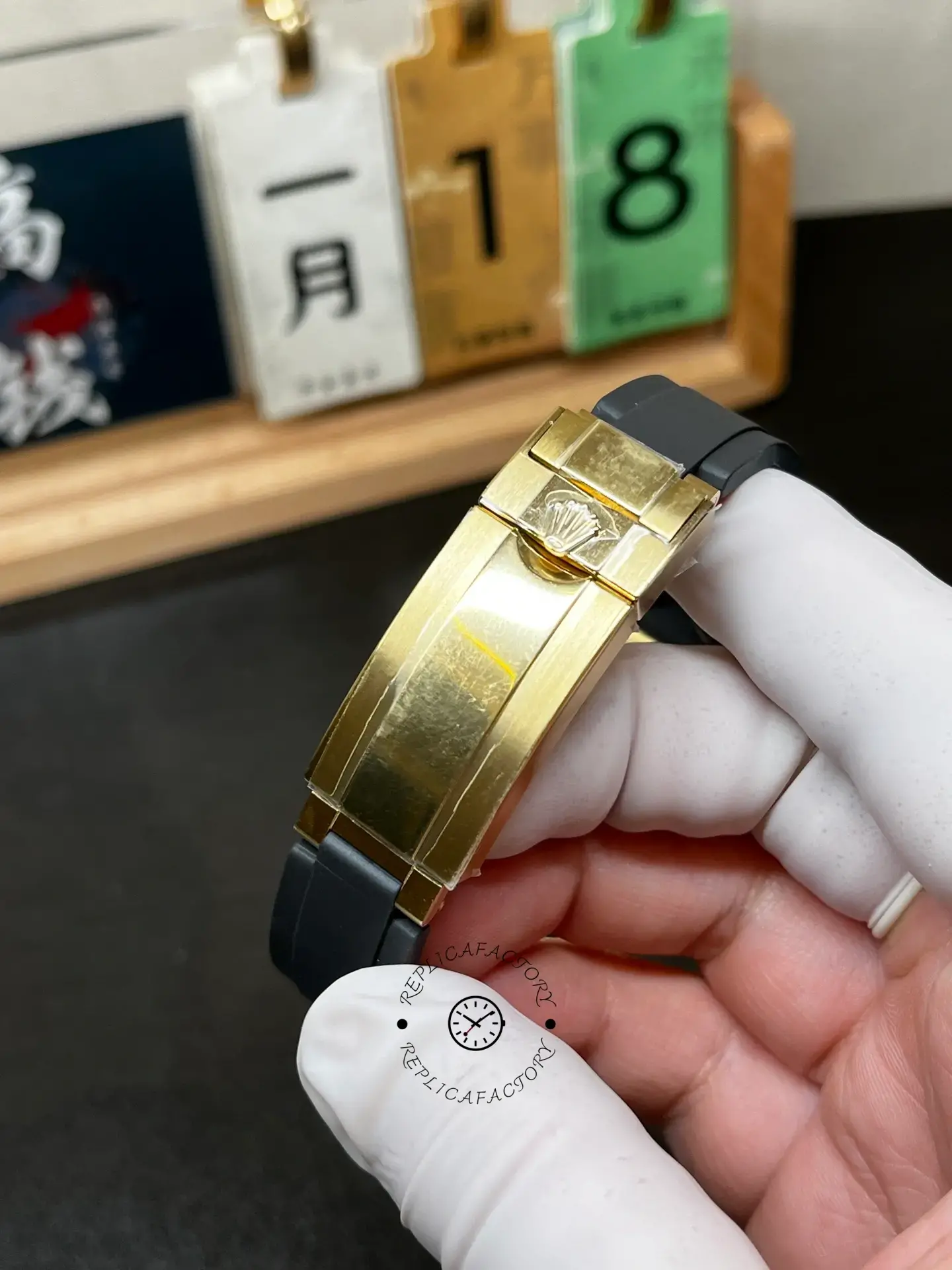 Handheld clasp view of Rolex Daytona 126518LN-0012 showing the gold-tone folding clasp.