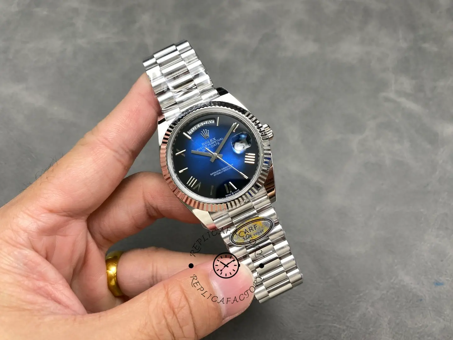 Rolex Day-Date 228239-0076 blue ombre dial front view with fluted bezel held in hand and President bracelet