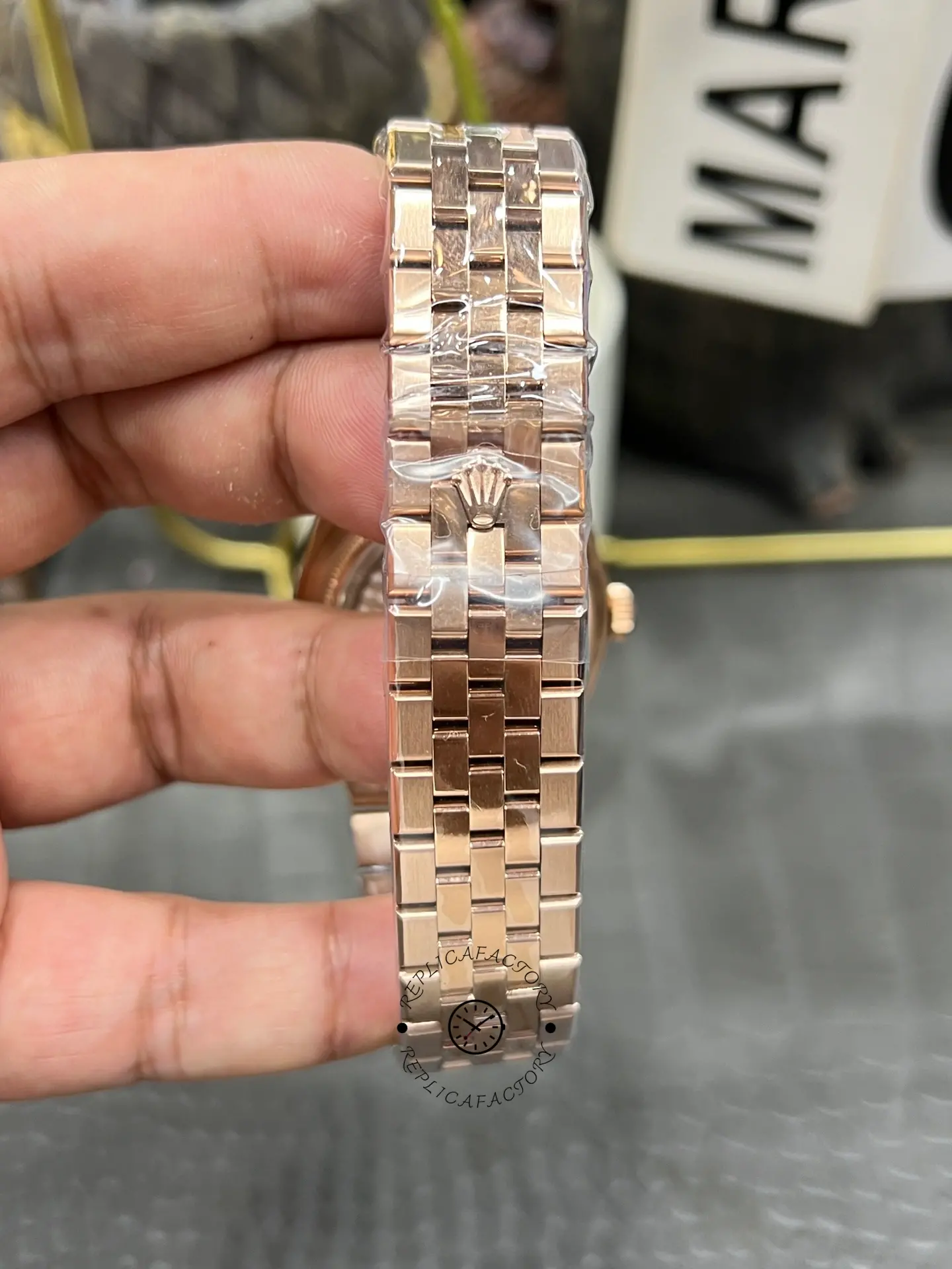 Bracelet close-up of Rolex Land Dweller m127385tbr-0003 showing the rose gold-tone clasp exterior and links.