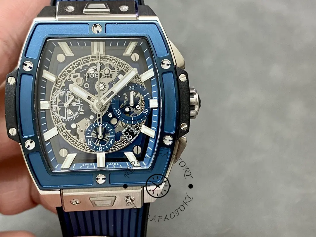 Handheld front view of Hublot 642.NL.7170.RX highlighting the blue bezel screws and skeleton dial.