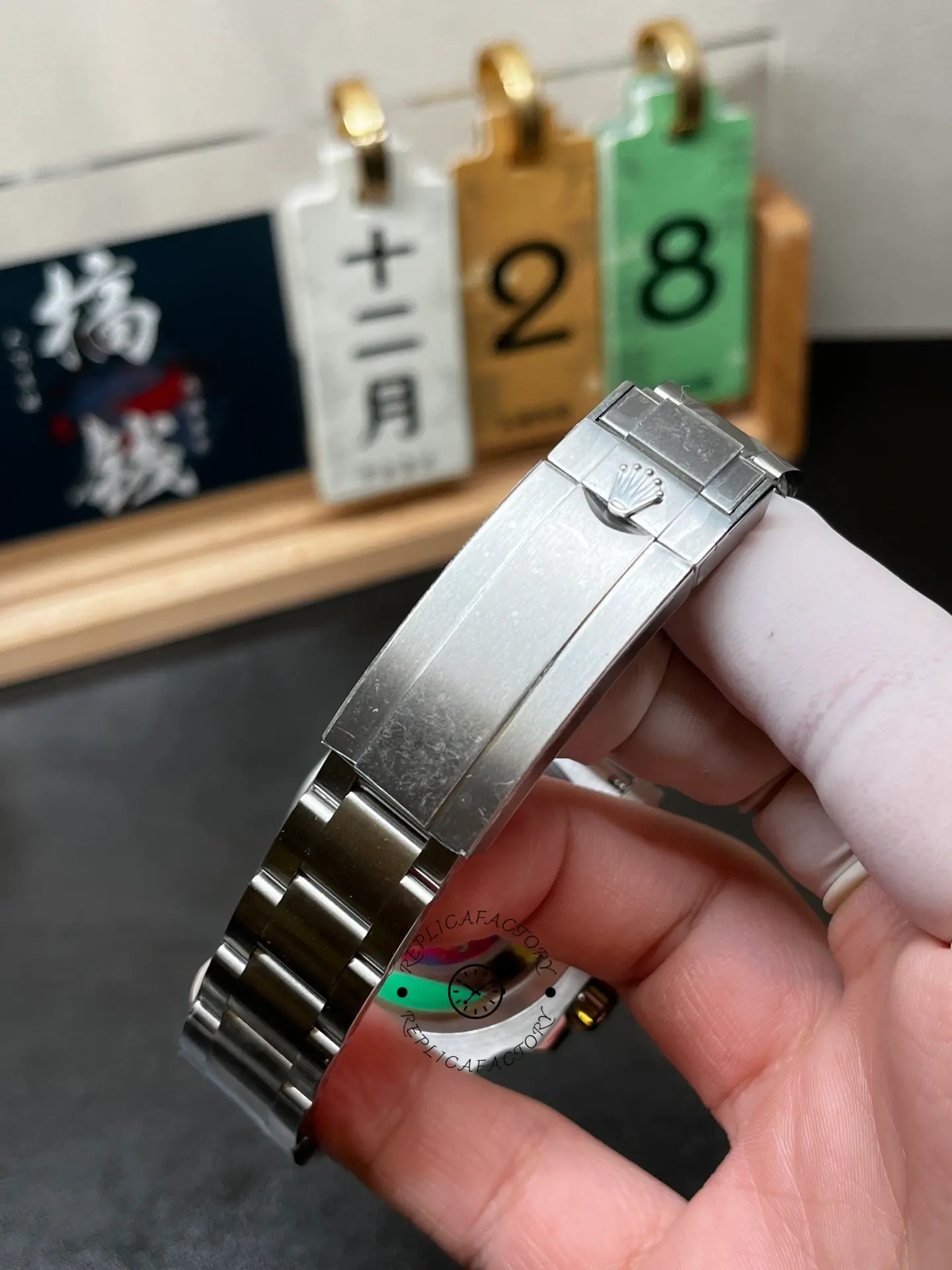 Close-up of Rolex 116610LV Submariner Date clasp showing brushed steel finish and engraved crown logo.