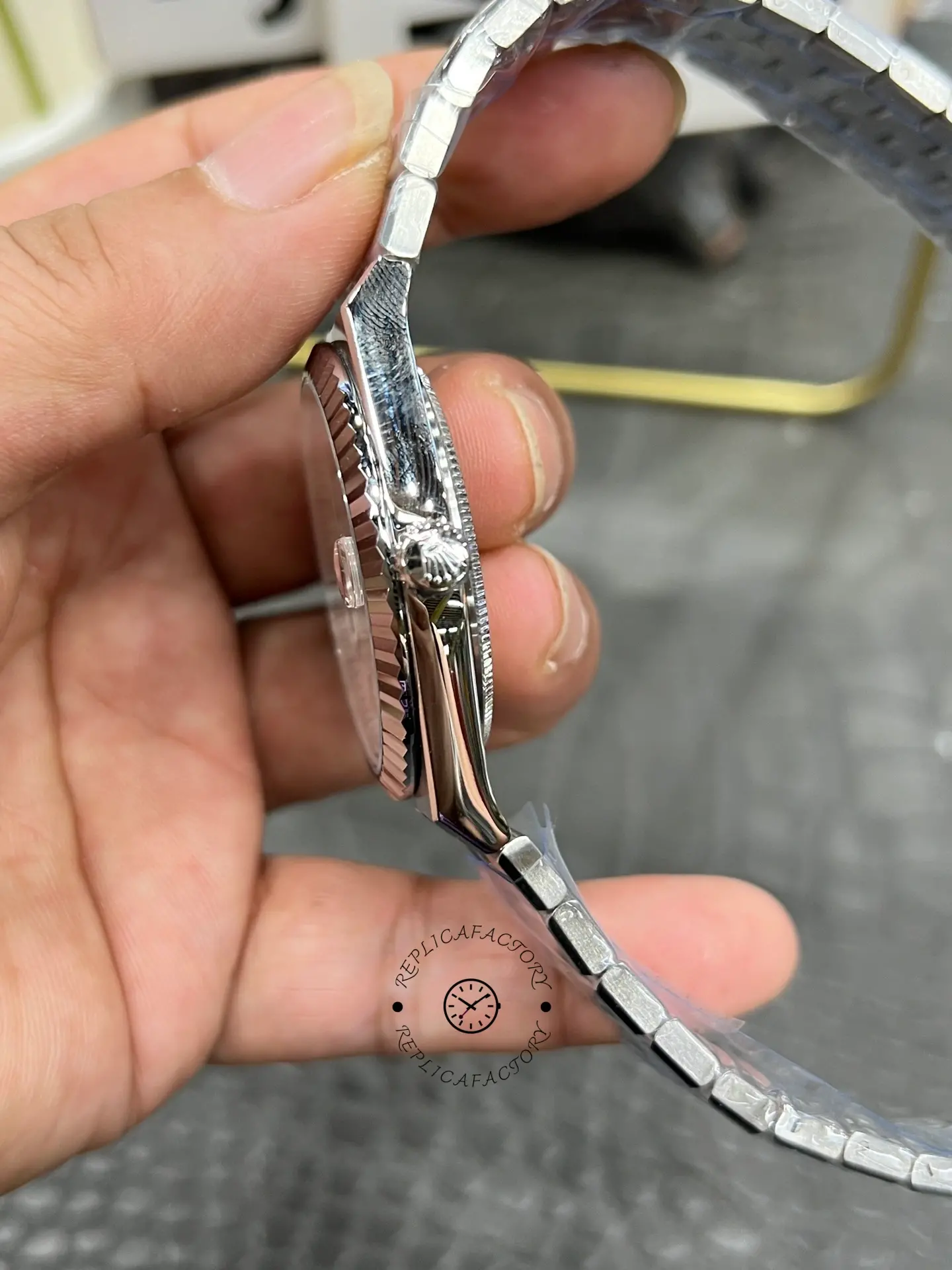 Side profile of Rolex Land-Dweller 40 M127334-0001 replica showing case shape, crown and fluted bezel edge.