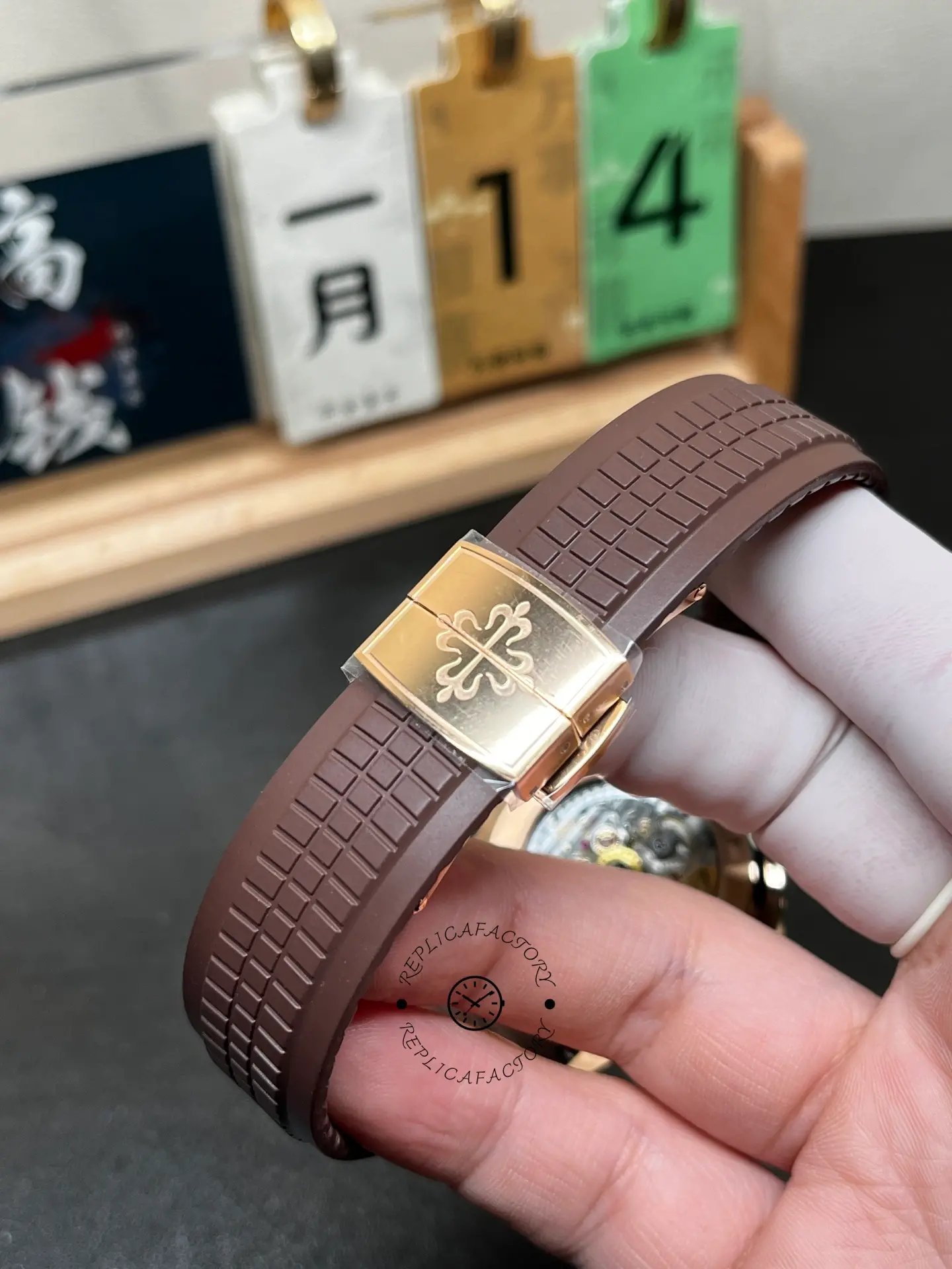 Patek Philippe Aquanaut 5167R-001 clasp close-up, Calatrava cross engraving on rose-gold buckle.