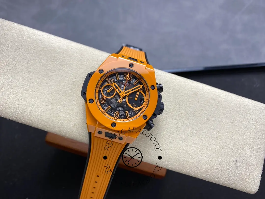 Full watch on display pillow: Hublot 441.CU.5910.RX orange ceramic chronograph with orange rubber strap.