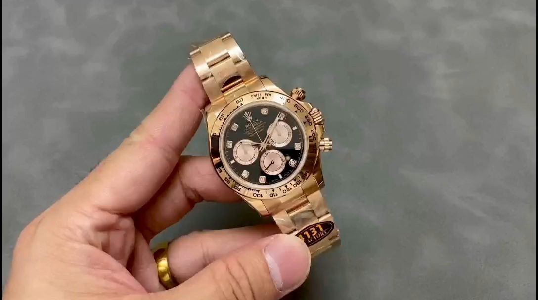 Video: hand holding Rolex Daytona 116508, black dial and gold bezel visible. - Video