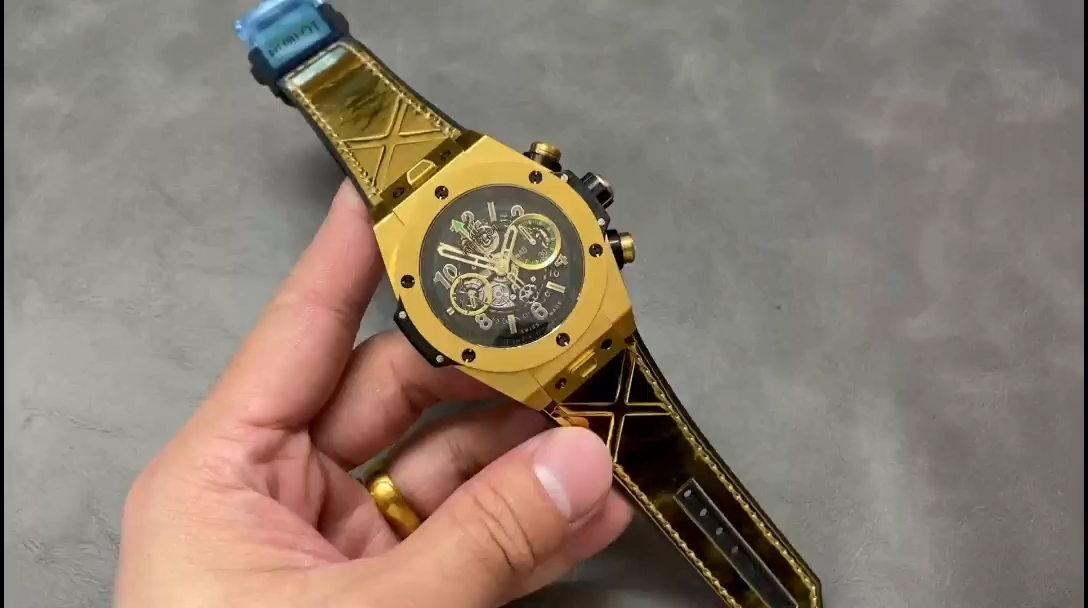 Wrist photos of the Hublot Big Bang 411.VX.1189.VR.USB16, featuring a black strap and gold case. - Video