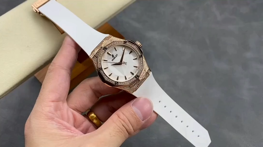 Hand-held strap view of the Hublot Classic Fusion 550.OS.2200.RW.1604.ORL20 showing white rubber texture. - Video