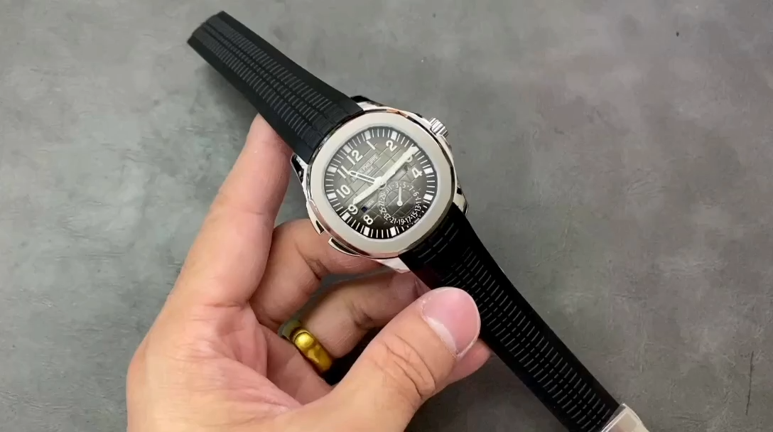 Hand-held view of the Patek Philippe Aquanaut 5164A-001 showing the black dial and steel case. - Video