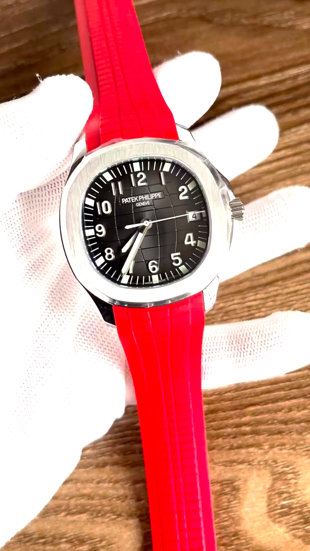 Video: hand-held Patek Philippe Aquanaut 5167A-012 showing red rubber strap texture and case finish. - Video