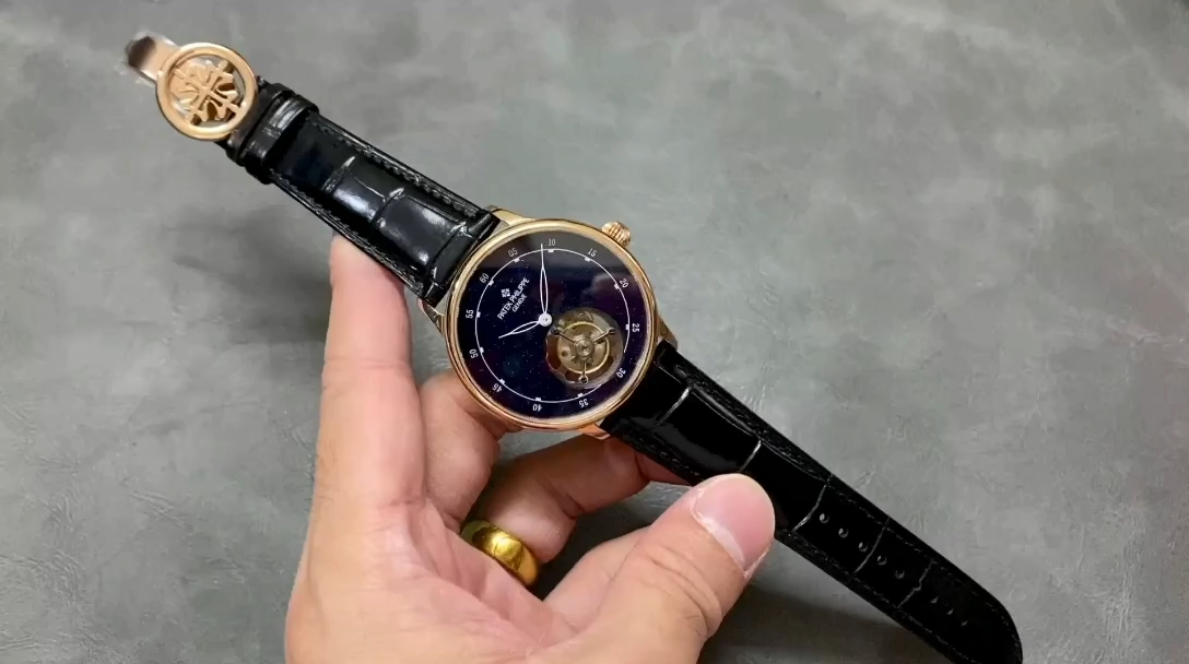 Hand-held shot of the Patek Philippe 6102P 001 showing the black leather strap and rose gold lugs. - Video