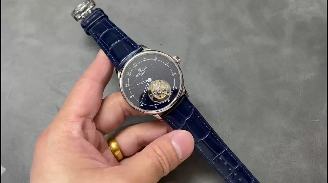 Hand-held view of Patek Philippe 6102P 001 showing sky chart dial and blue leather strap. - Video