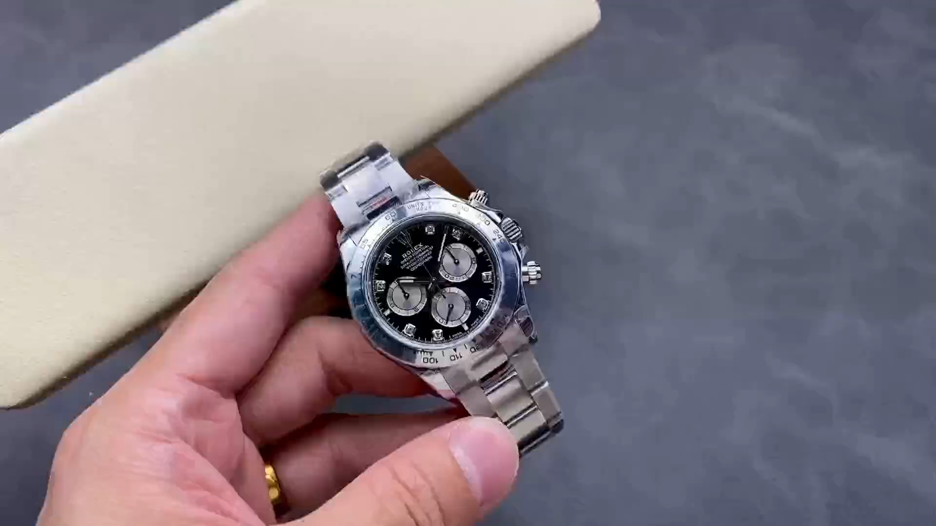 Video: hand holding Rolex Cosmograph Daytona 126509-0002, diamond markers and bezel visible. - Video