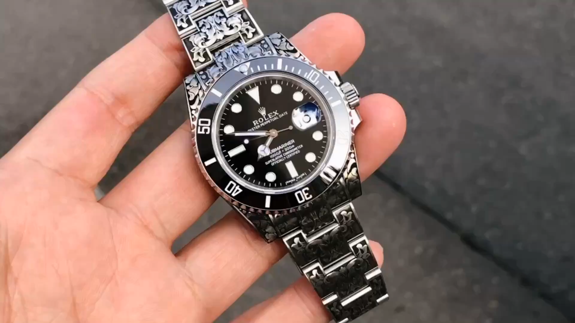 Hand-held view of the Huckleberry Custom Rolex Submariner showing the dial and bracelet. - Video