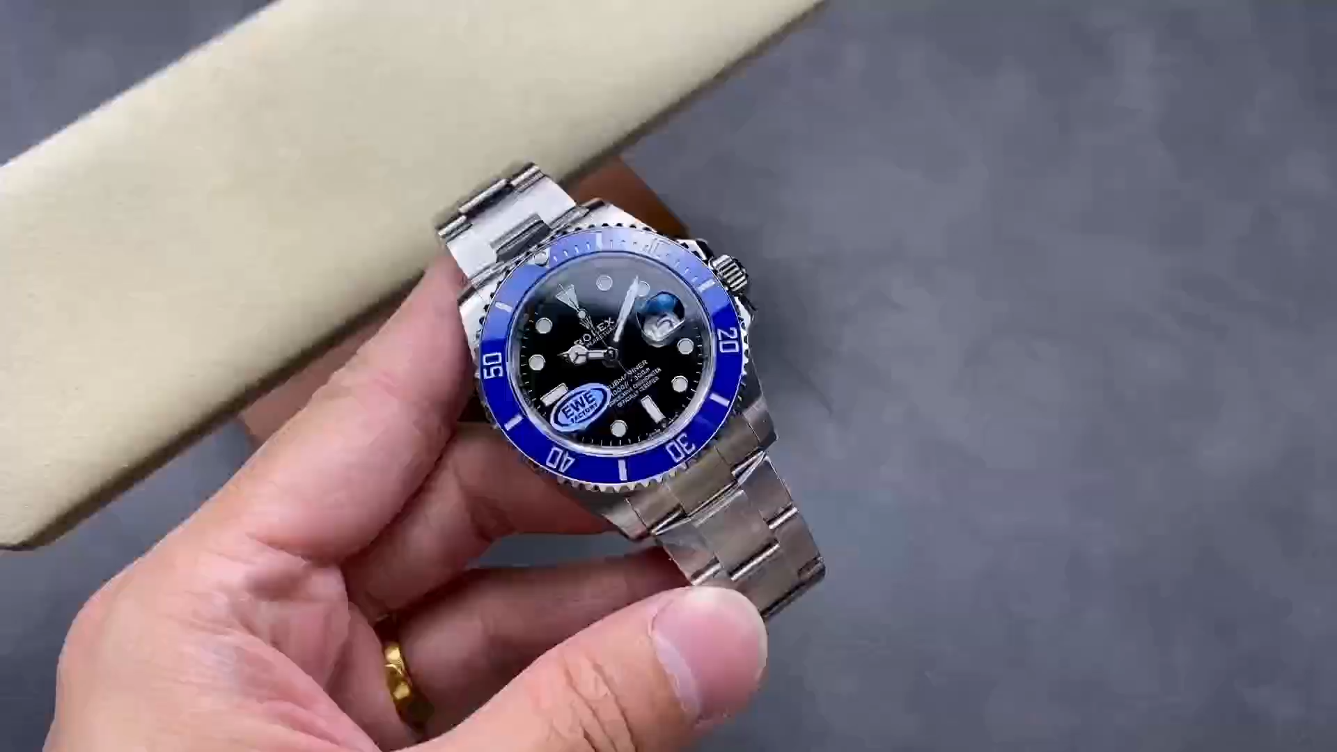 Rolex Submariner 126619LB 0003, front view held in hand, blue bezel visible. - Video