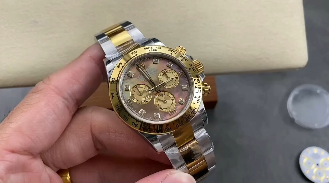 Video: hand holding Rolex Daytona 116523, dark MOP dial and two-tone bracelet visible. - Video